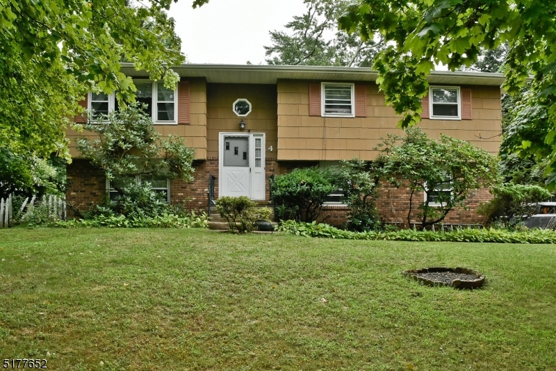 a yellow house with trees in the background