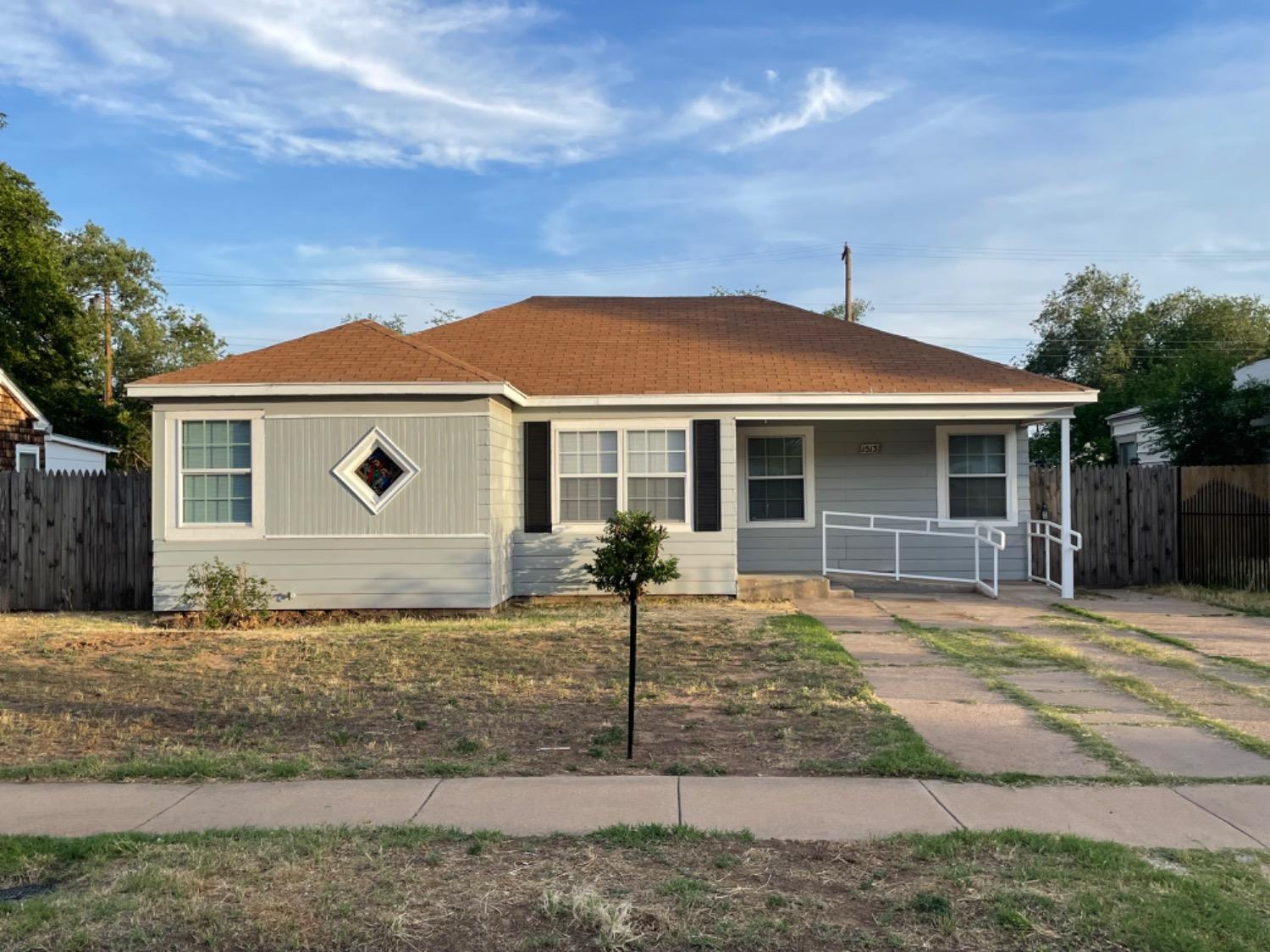 a front view of a house with yard and parking