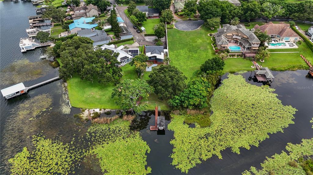 an aerial view of a house with a yard and lake view