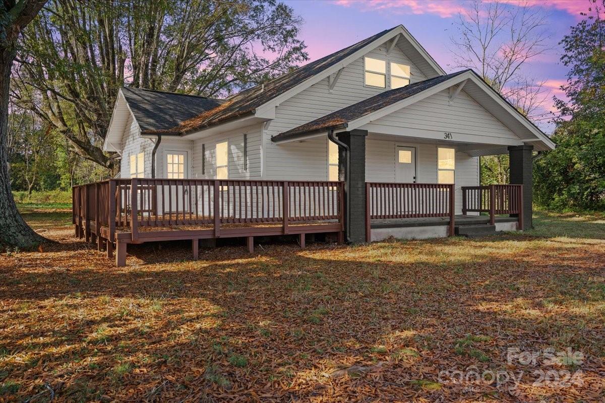 a view of a house with a yard and deck