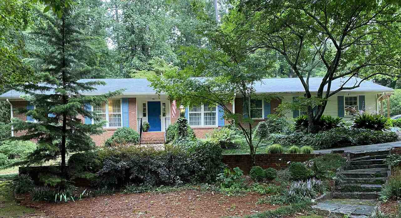 a front view of a house with plants and garden