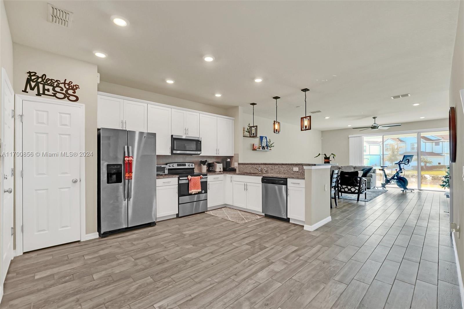 a kitchen with stainless steel appliances kitchen island wooden cabinets and refrigerator