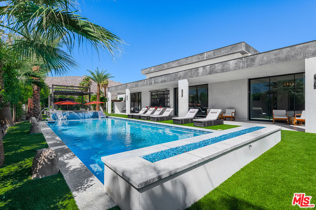 a view of a house with swimming pool and a small yard