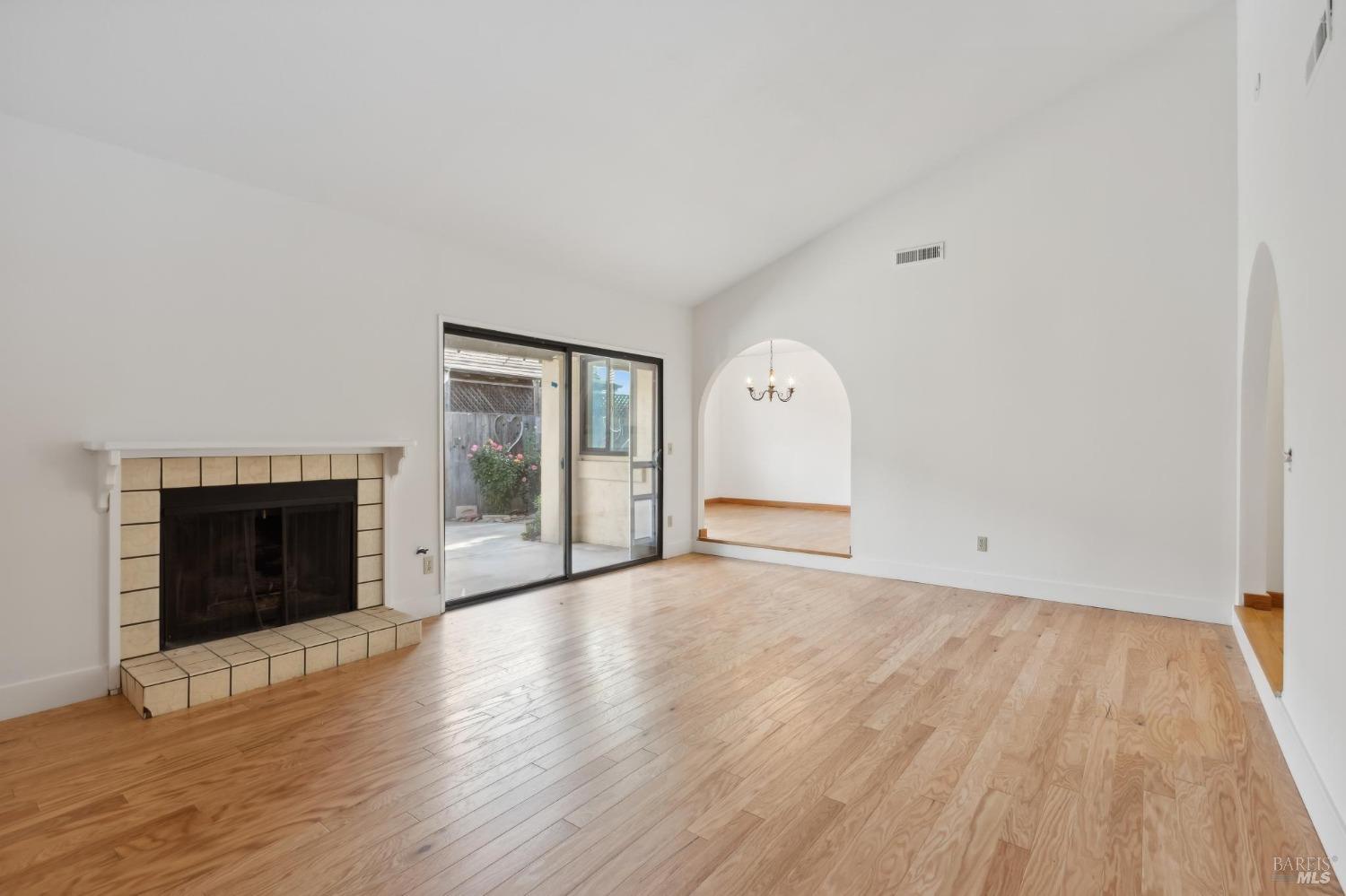 a view of empty room with wooden floor and fireplace