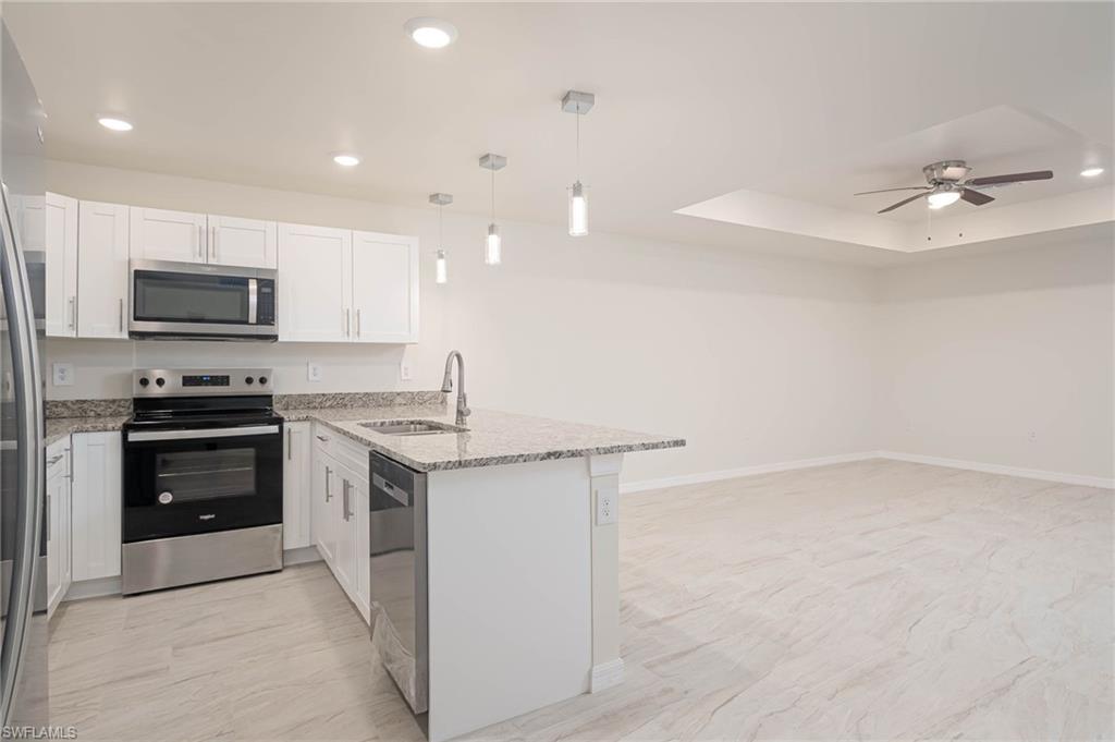 a kitchen with kitchen island a stove sink and microwave