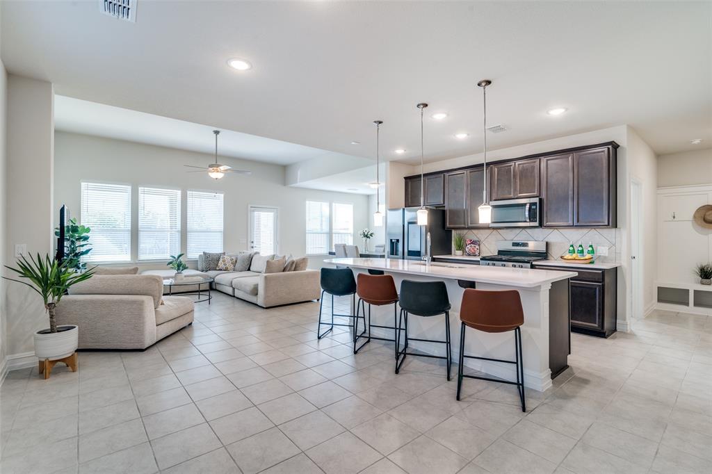 a living room with stainless steel appliances kitchen island granite countertop a couch and a view of living room