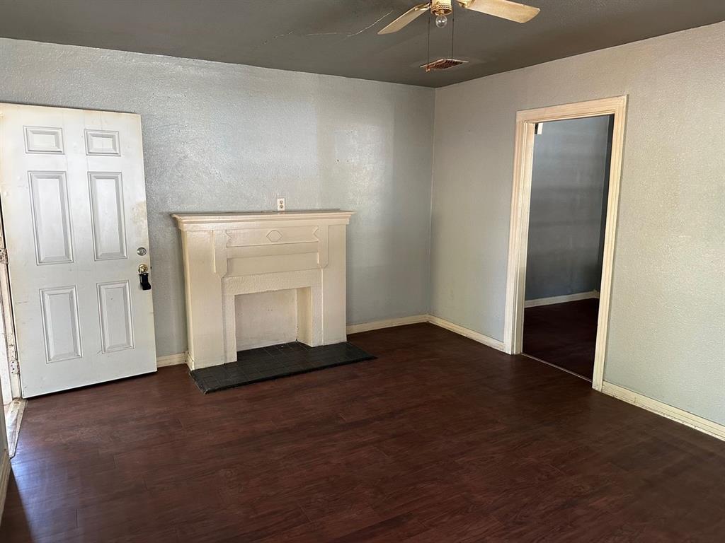 an empty room with wooden floor and cabinet