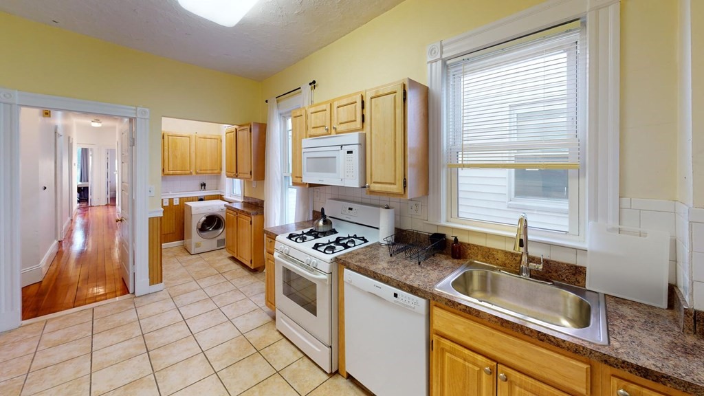 a kitchen that has a sink a stove and a refrigerator