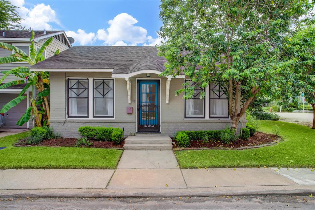 a front view of a house with a yard and potted plants