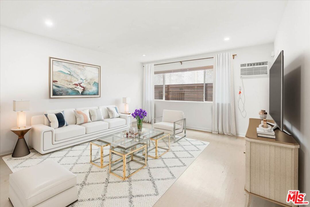 a living room with furniture a flat screen tv and a table