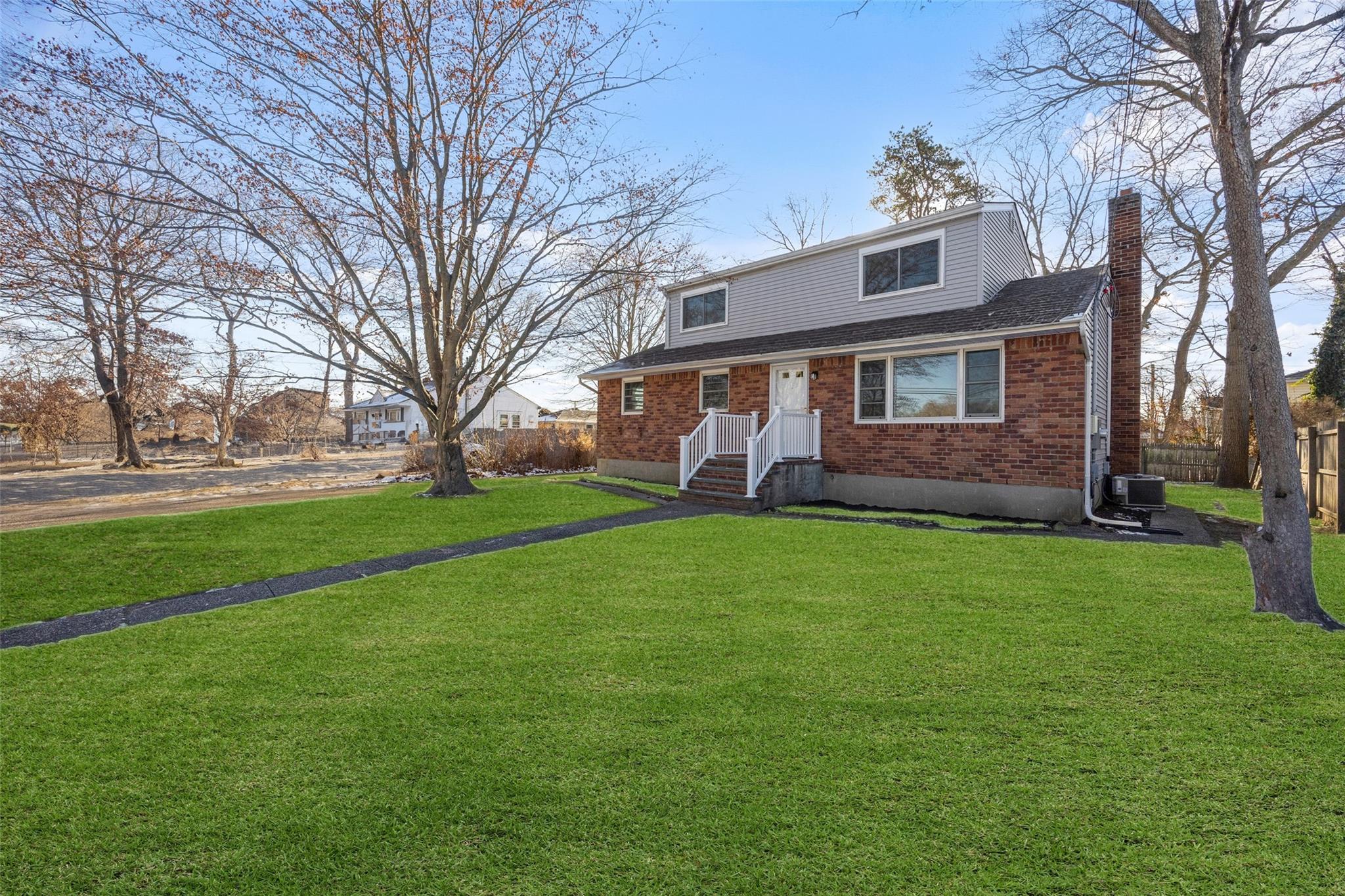 View of front of property featuring central AC and a front lawn