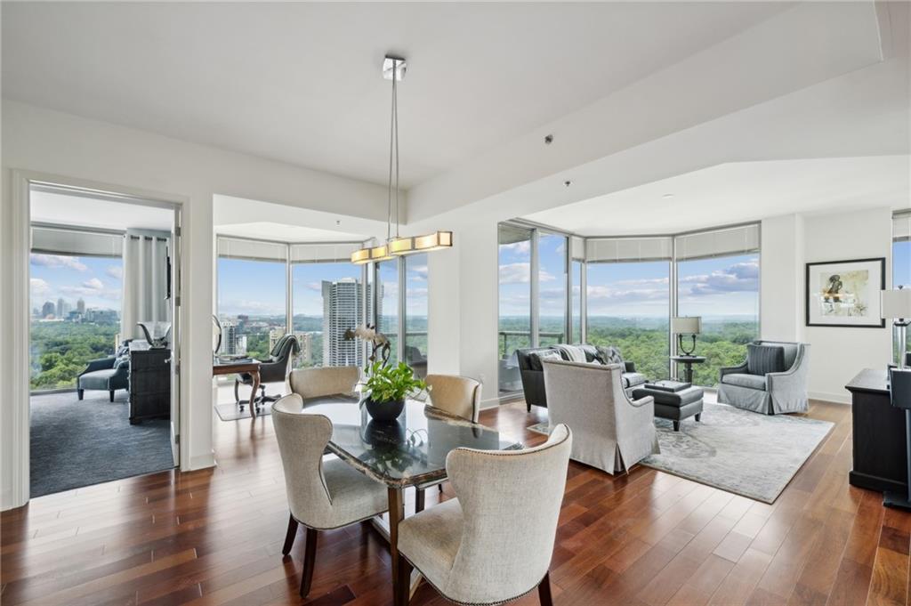 a view of a dining room and livingroom with furniture wooden floor a chandelier