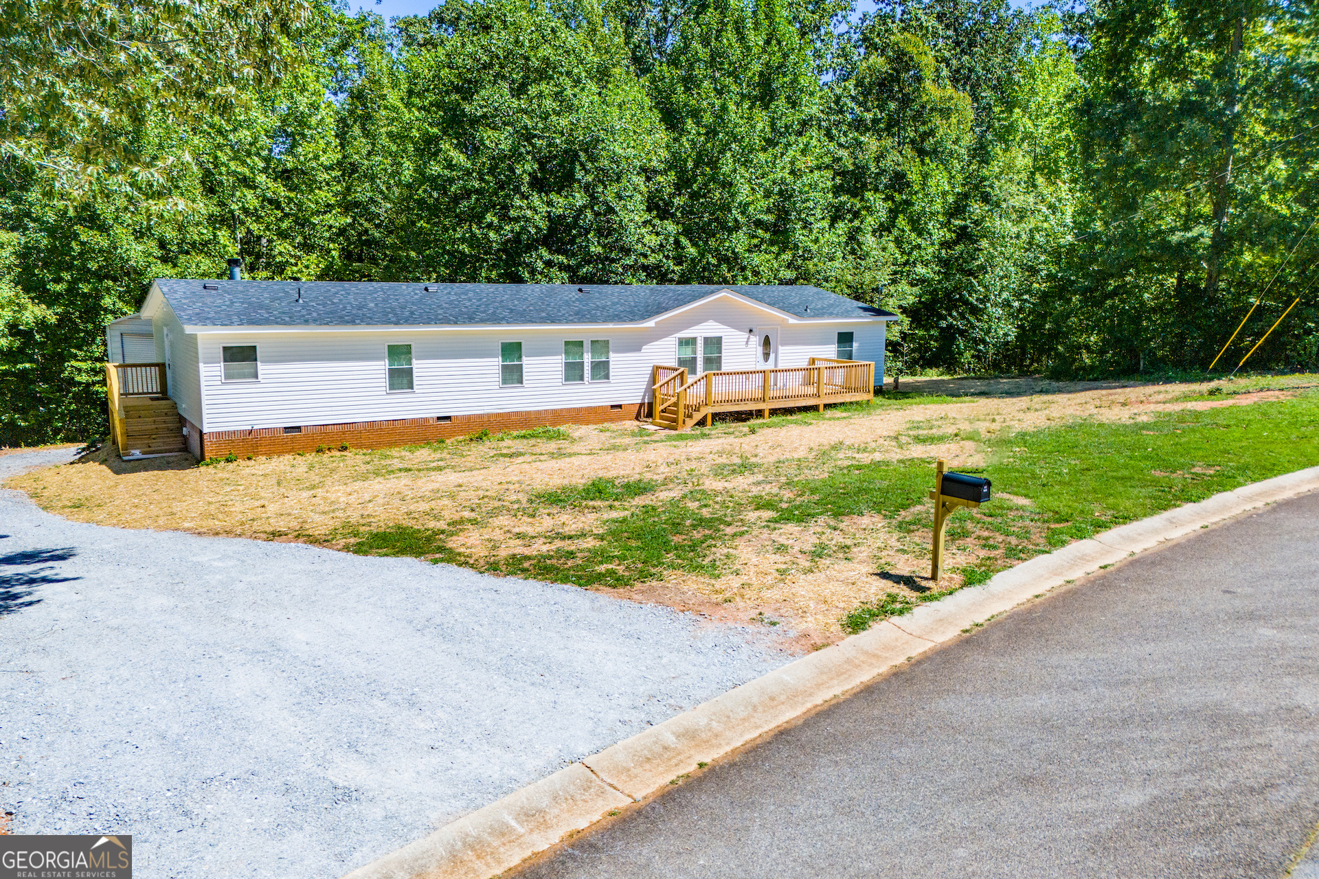 a view of a house with a yard and large tree