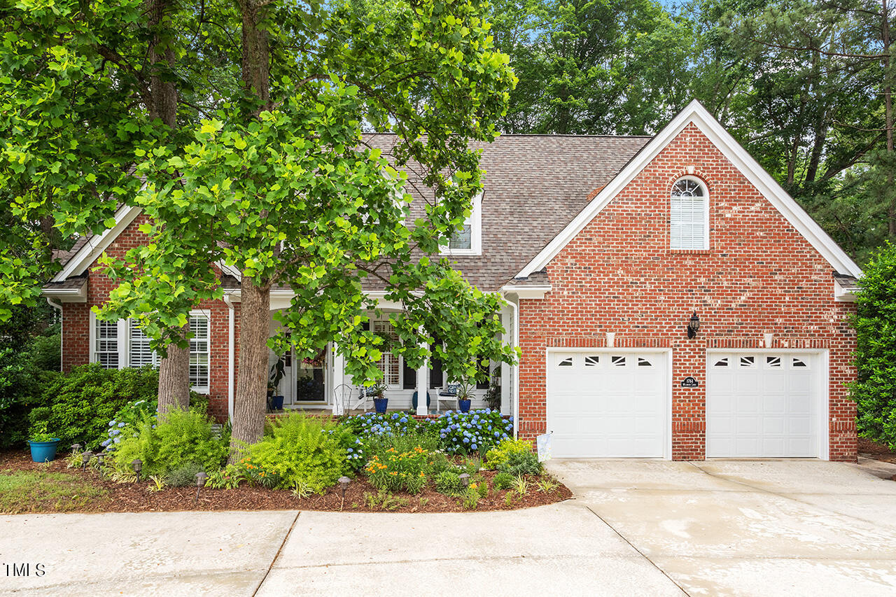 a front view of a house with a yard and trees