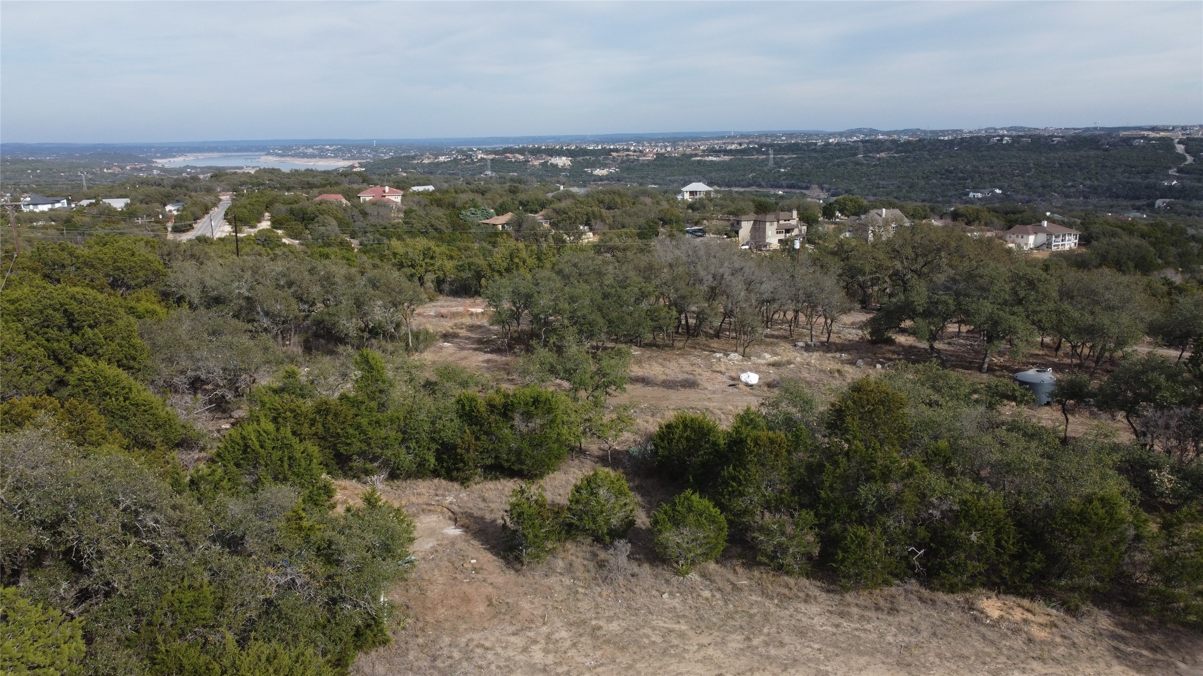 an aerial view of residential houses with outdoor space and trees