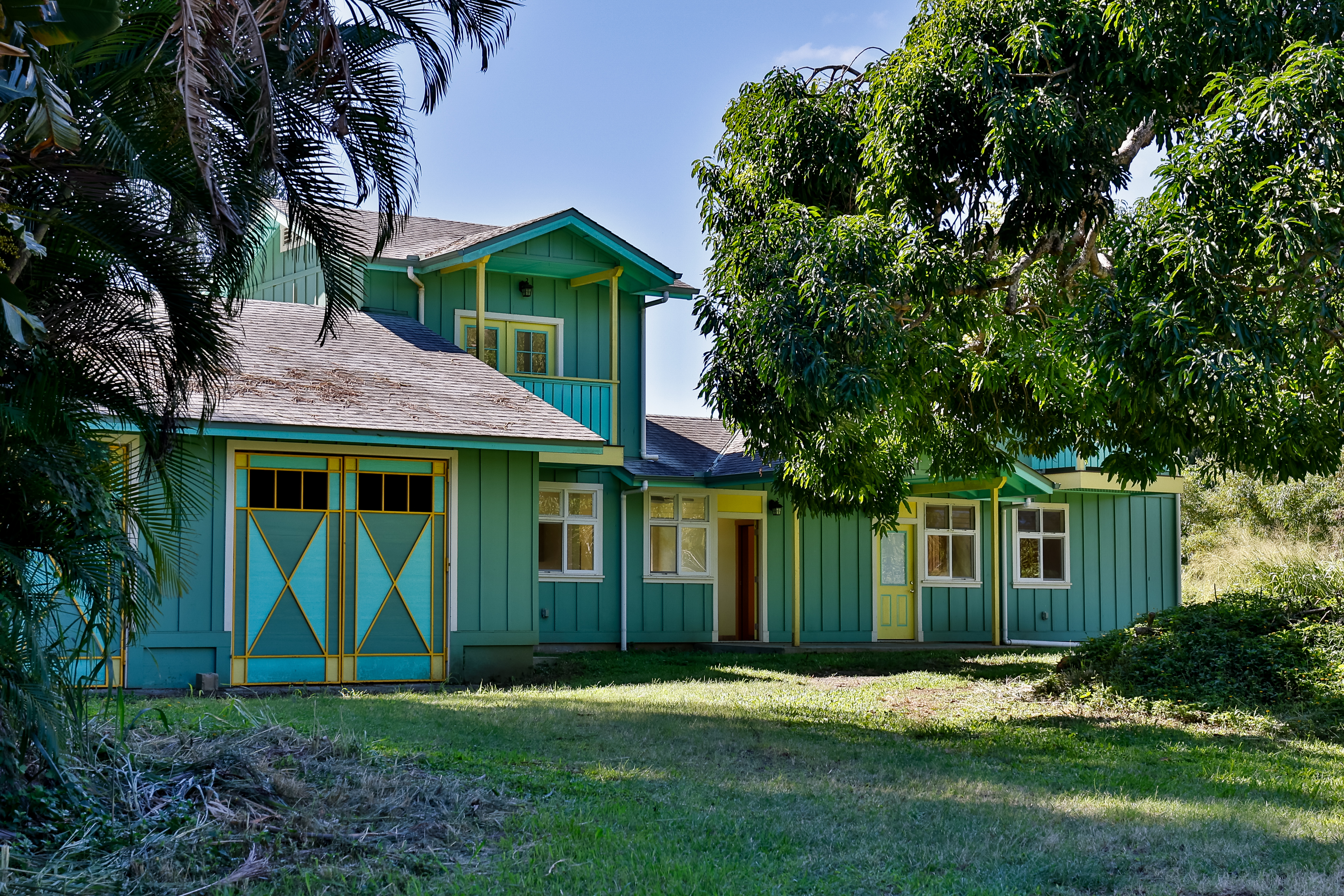 a front view of a house with a yard and trees