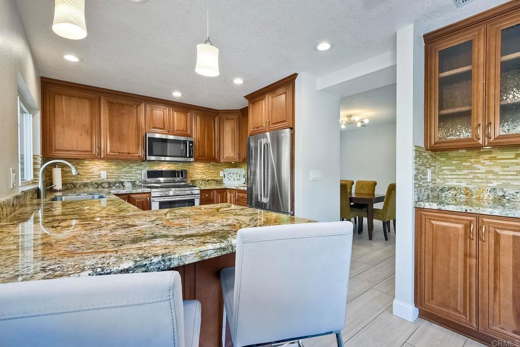 a kitchen with kitchen island granite countertop a sink appliances cabinets and furniture