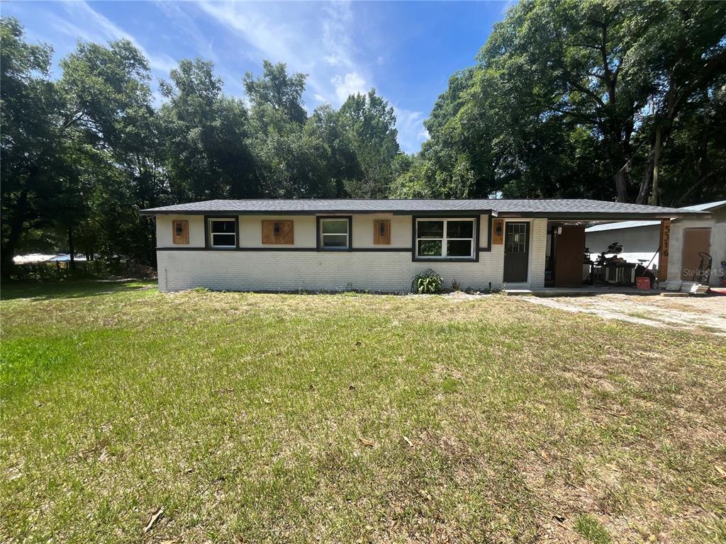 a front view of house with yard and trees around