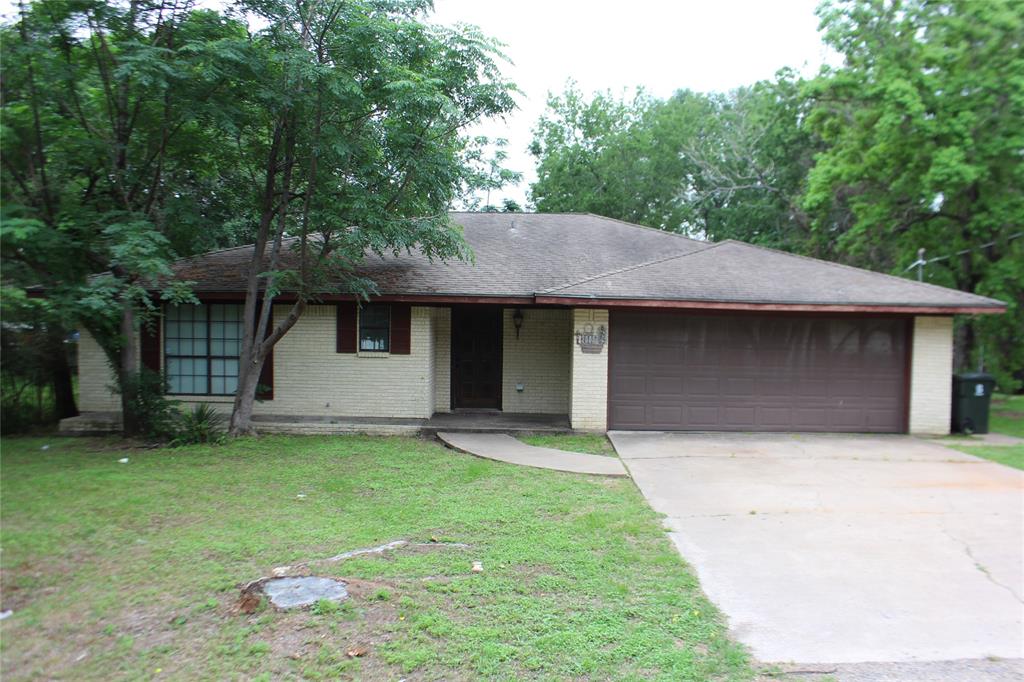 a front view of a house with a garden and trees