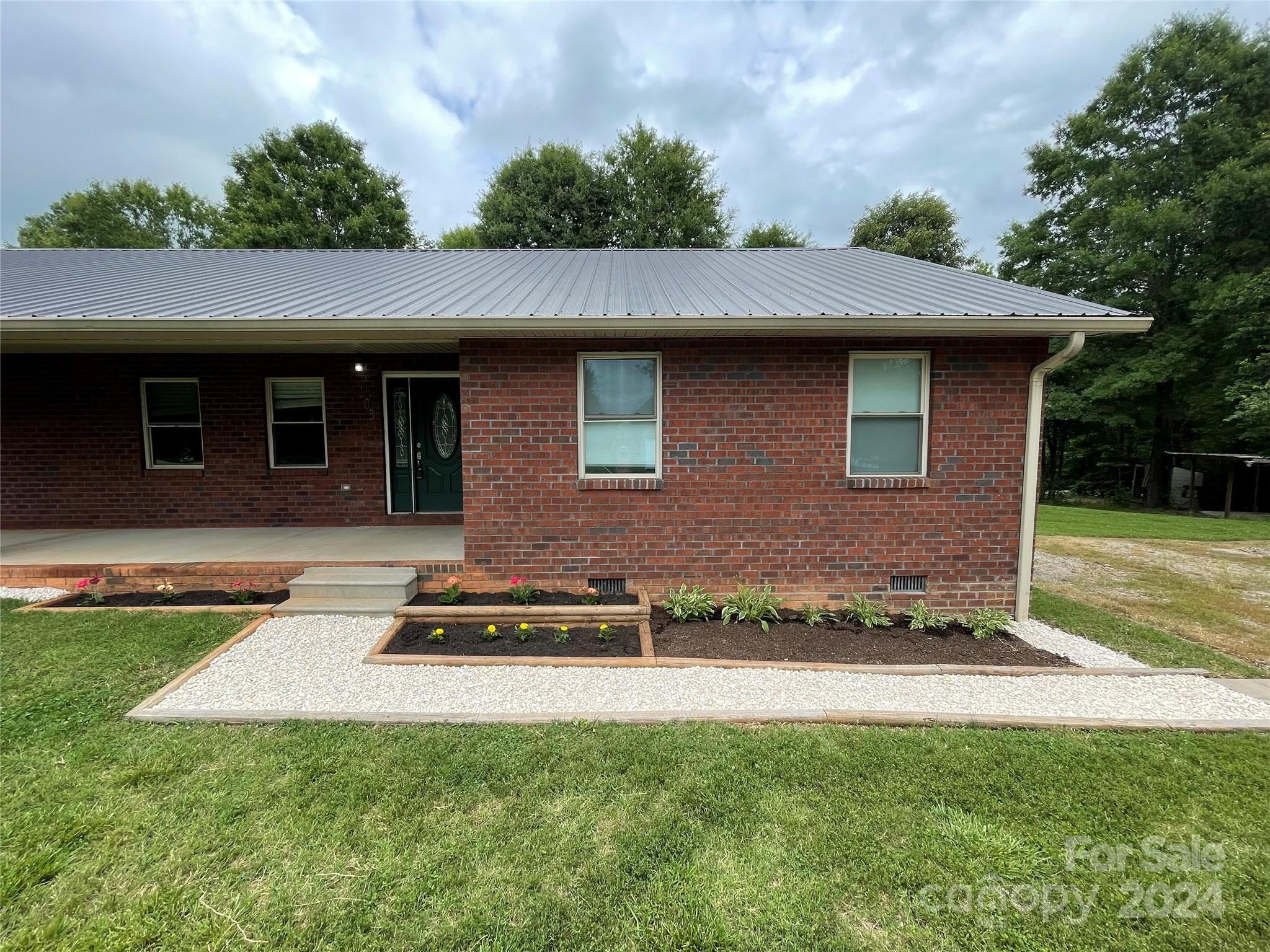 a front view of a house with a garden