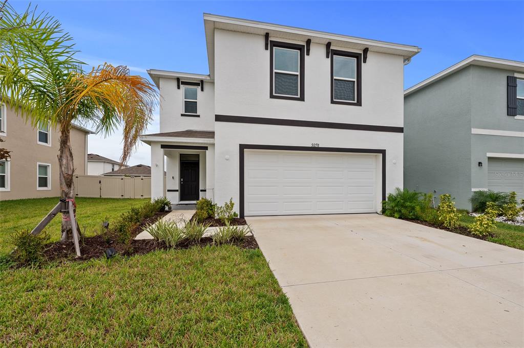 a front view of a house with a yard and garage