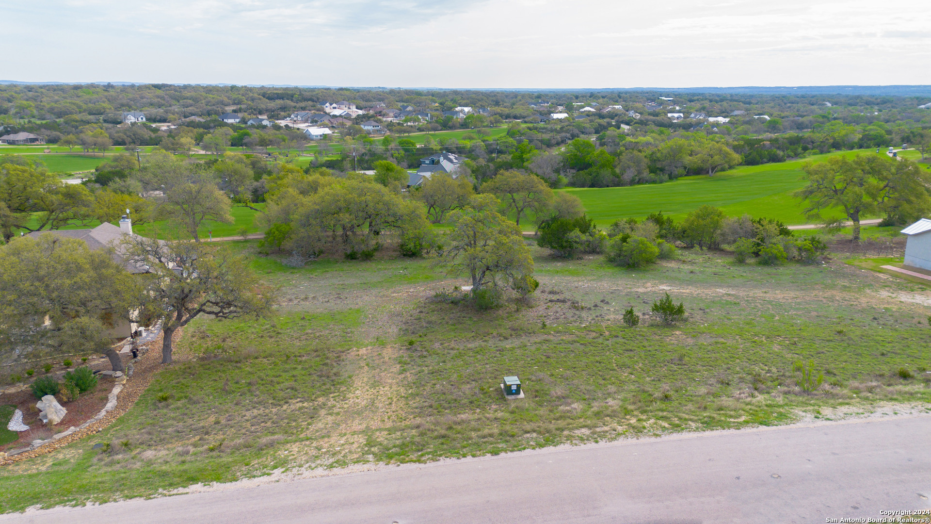 an aerial view of a houses with outdoor space and trees