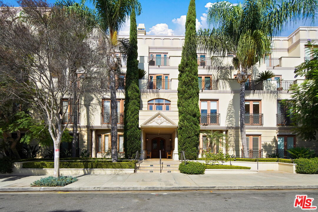 a front view of residential houses with street and trees