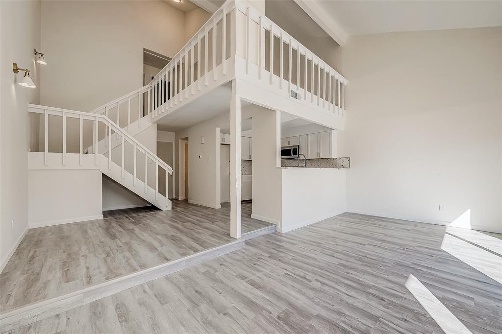 The open-concept living and dining area offers a seamless flow, perfect for entertaining guests or enjoying quality time with family in a spacious, inviting atmosphere. Above, you can also see the upgraded loft area overlooking the downstairs.