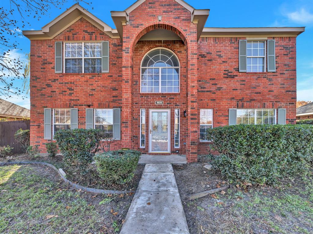 front view of a brick house with a yard