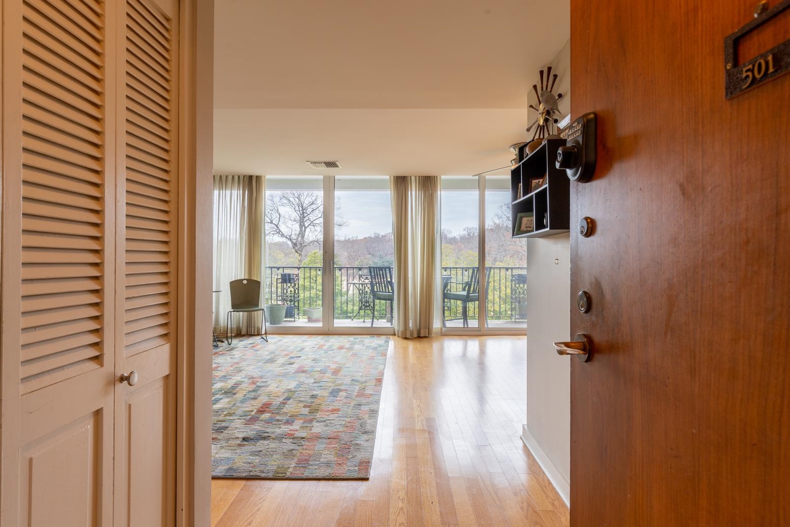 a view of a hallway with windows and chandelier