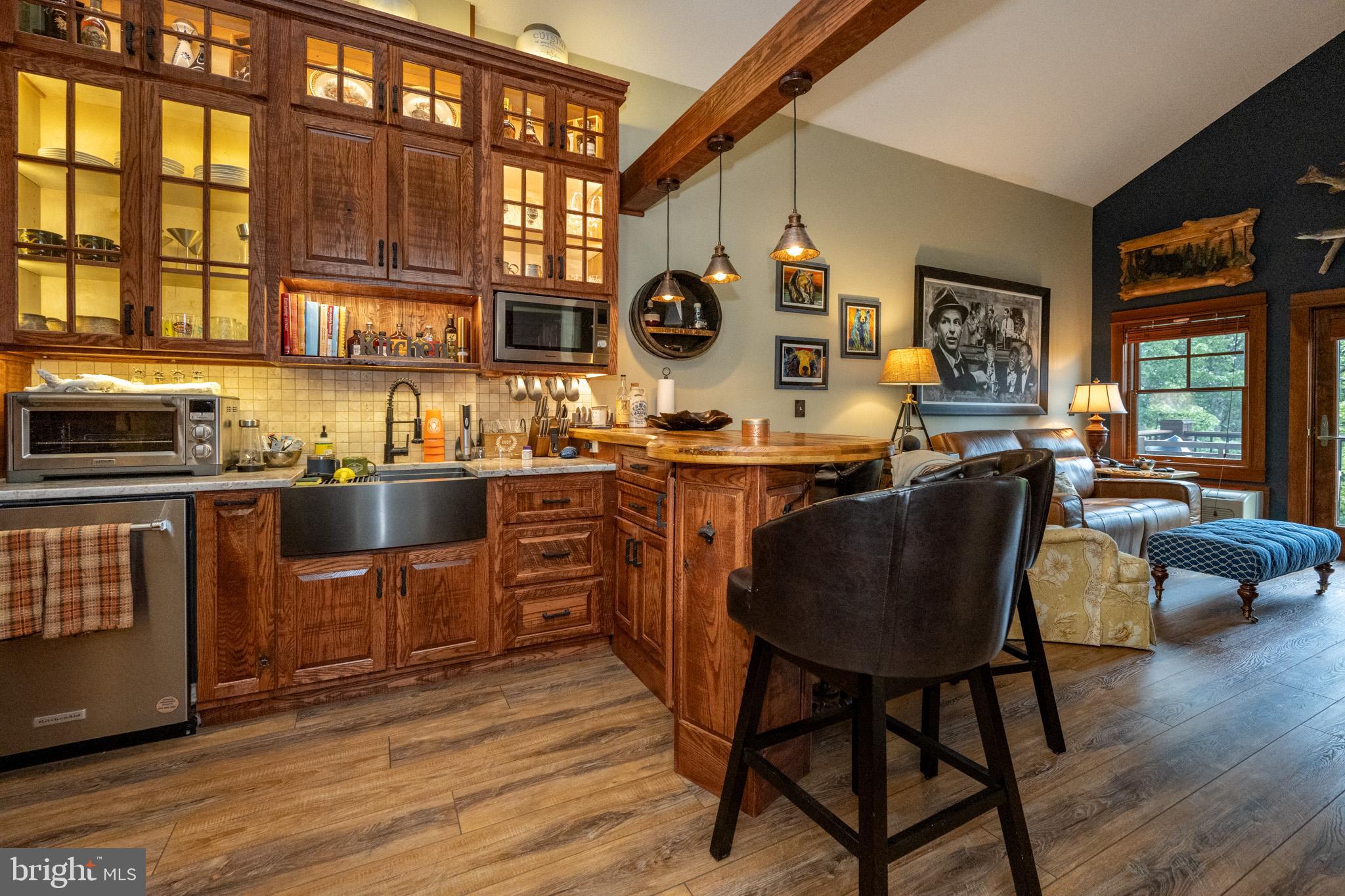 a kitchen with stainless steel appliances granite countertop wooden floors and large window