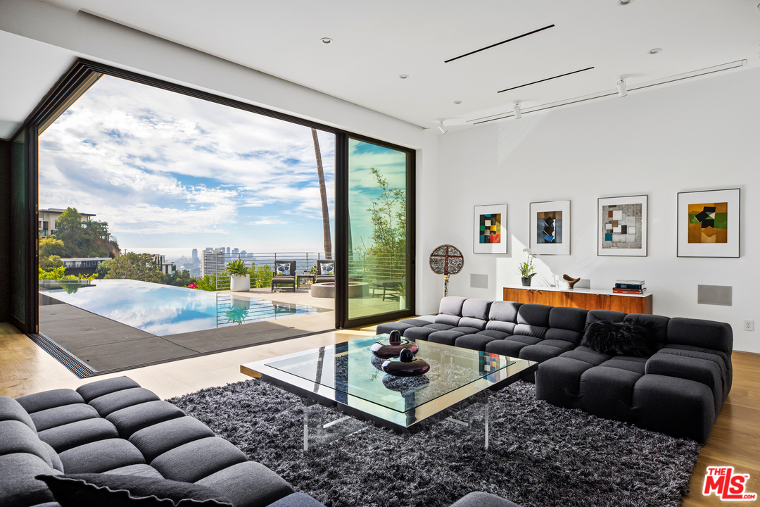 a living room with furniture large window and a table