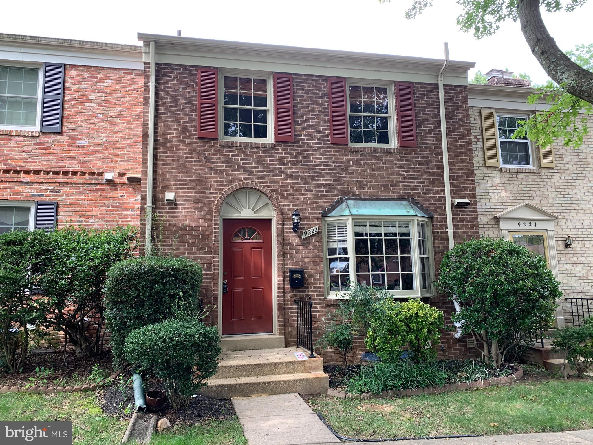 a front view of a house with yard and green space