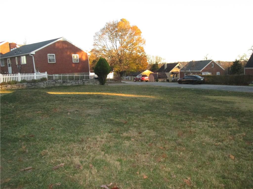 a view of a houses with a big yard and large trees