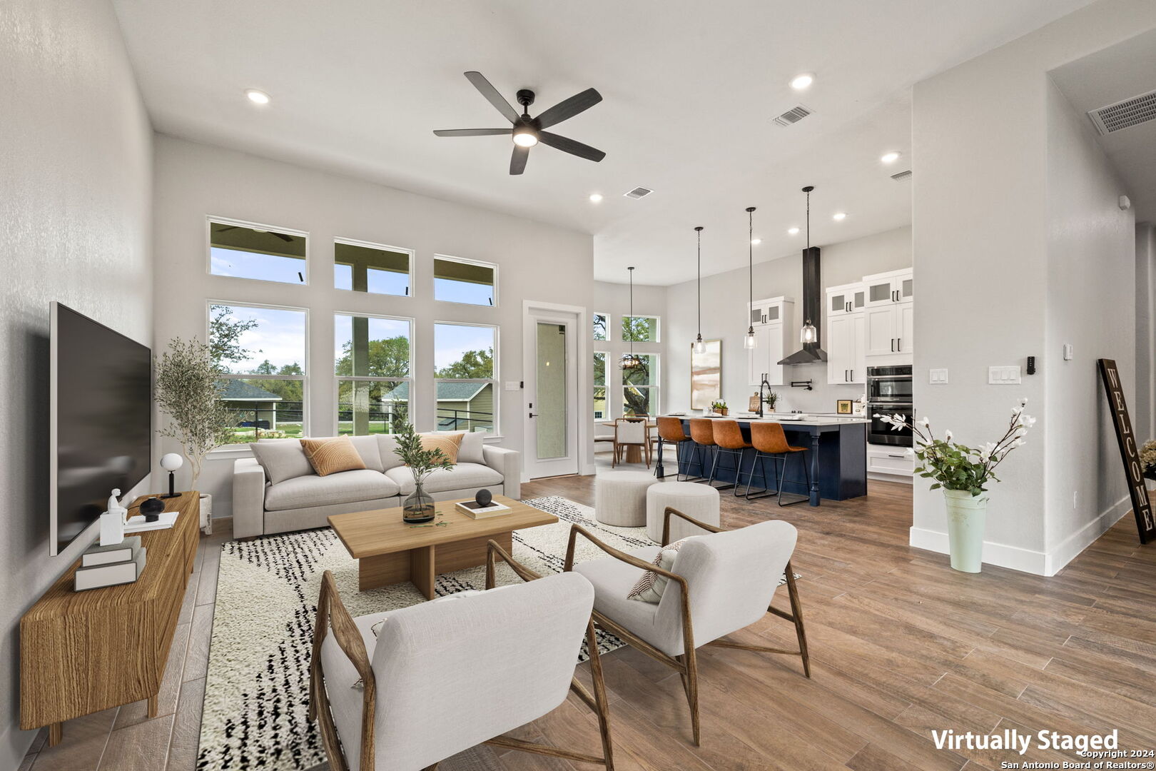 a living room with furniture kitchen view and a large window