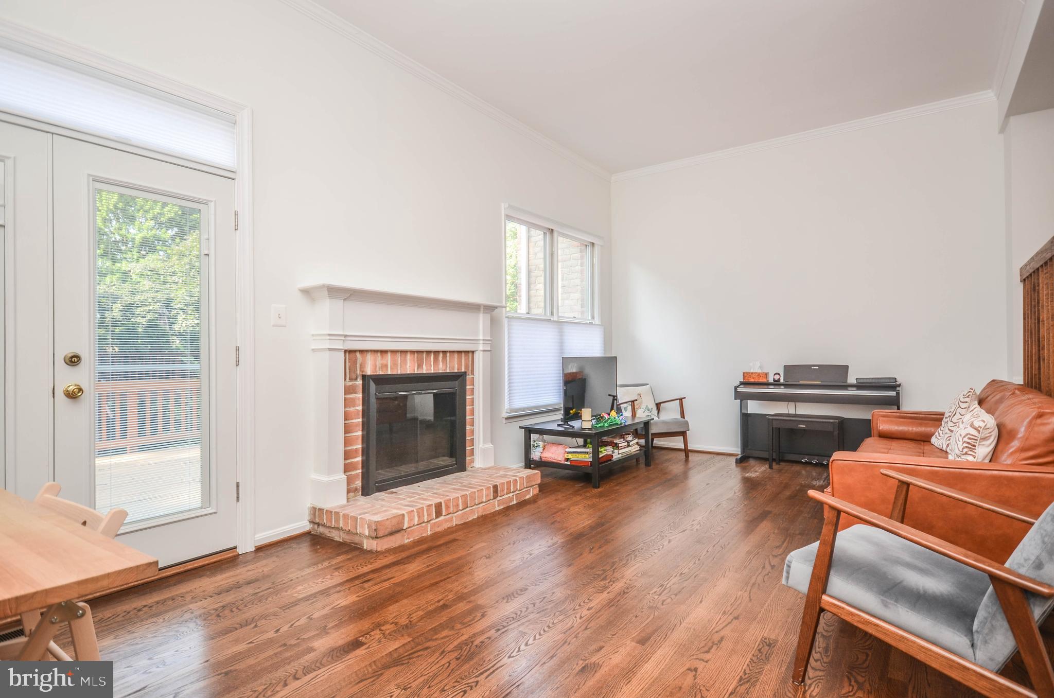 a living room with furniture fireplace and wooden floor