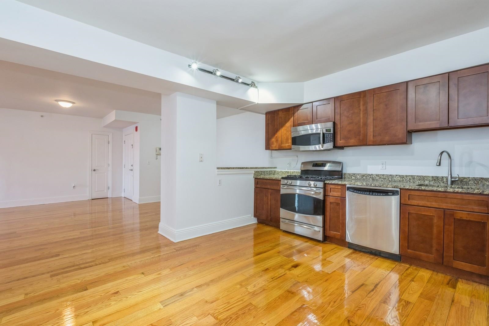 a kitchen with stainless steel appliances granite countertop a stove a sink dishwasher and a refrigerator