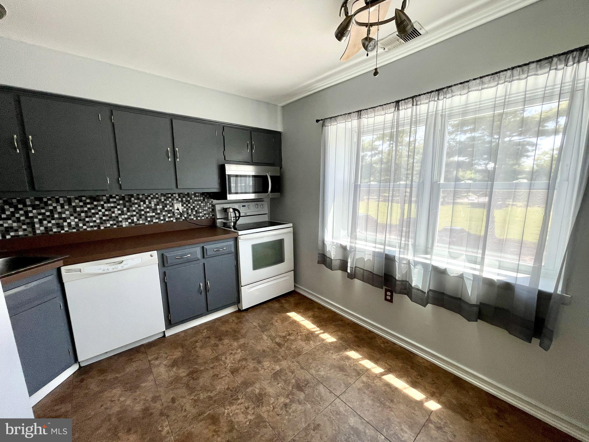 a kitchen with stainless steel appliances a sink window and cabinets