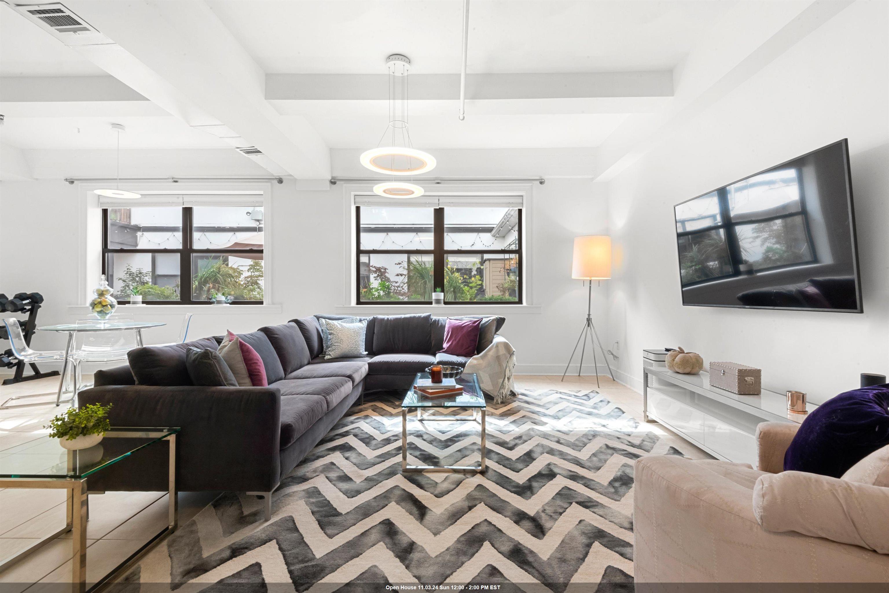 a living room with furniture a flat screen tv and a large window