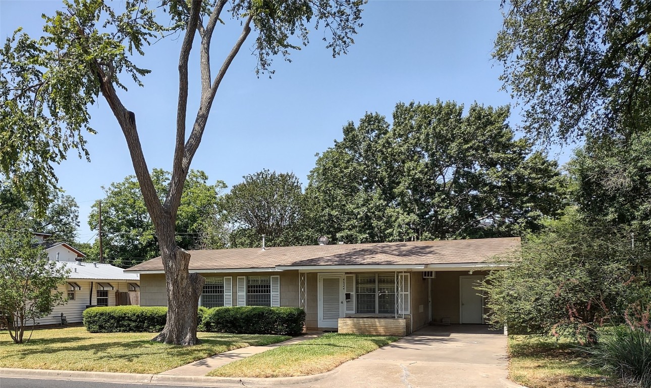 a front view of a house with a tree