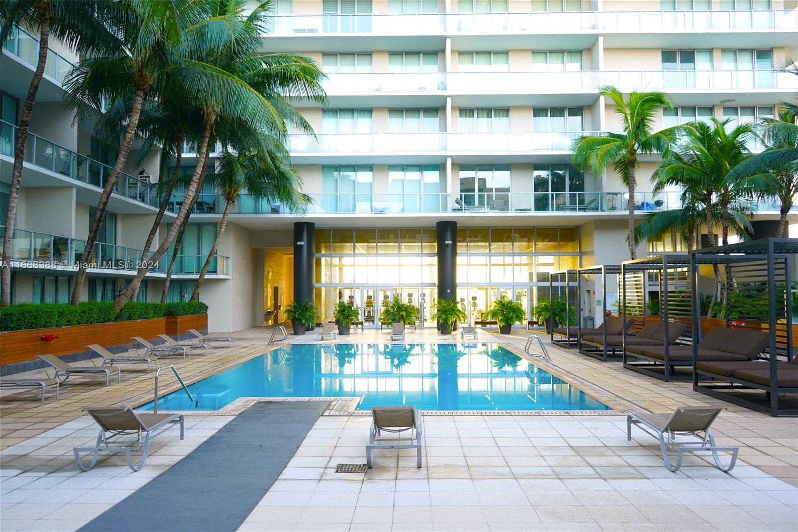 a view of swimming pool with a lounge chairs in front of house