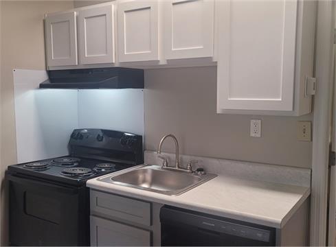 a kitchen with sink stove and cabinets