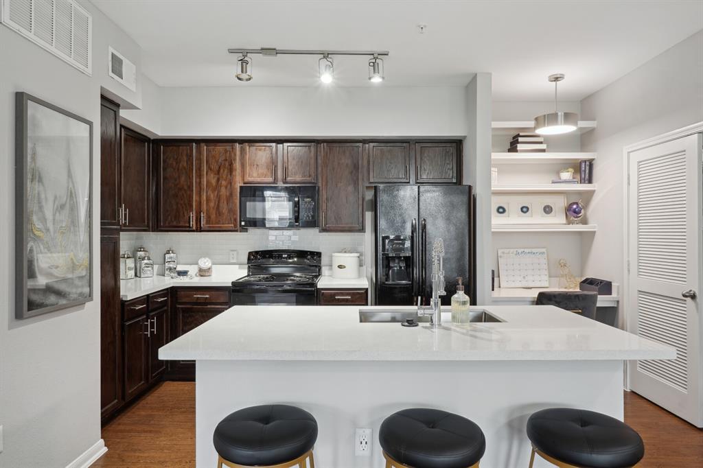 a kitchen with kitchen island a sink stainless steel appliances and cabinets