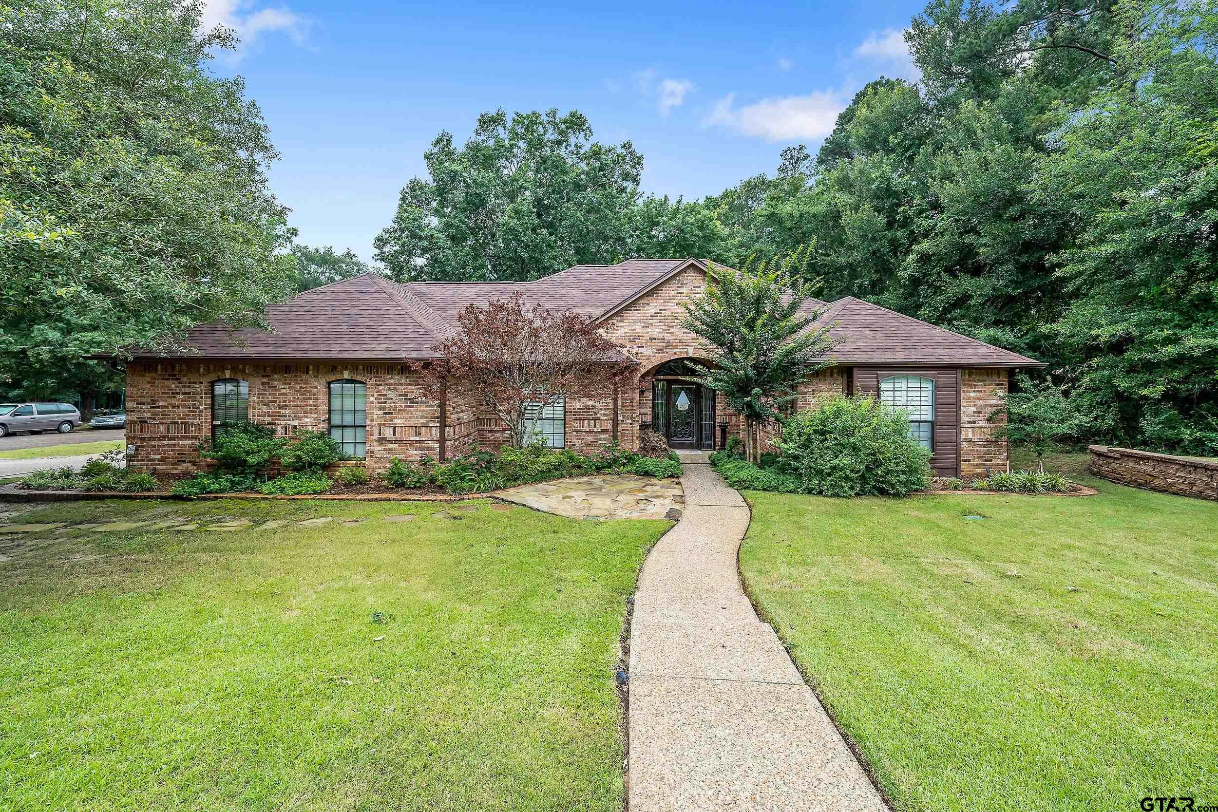 a front view of a house with yard patio and green space