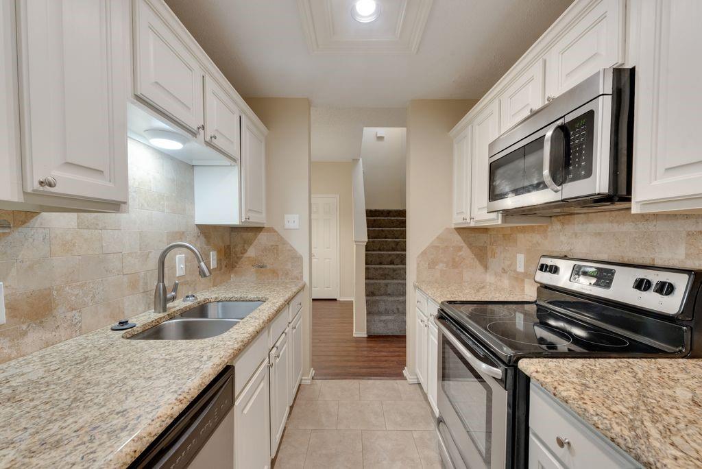 a kitchen with stainless steel appliances granite countertop a sink stove and microwave