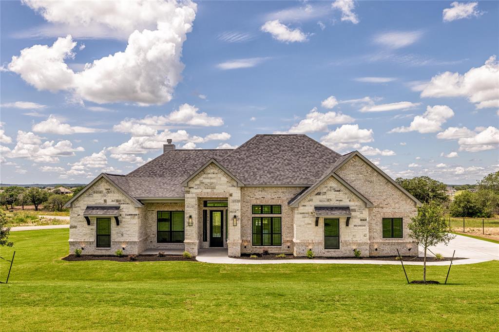 a front view of a house with a garden and trees