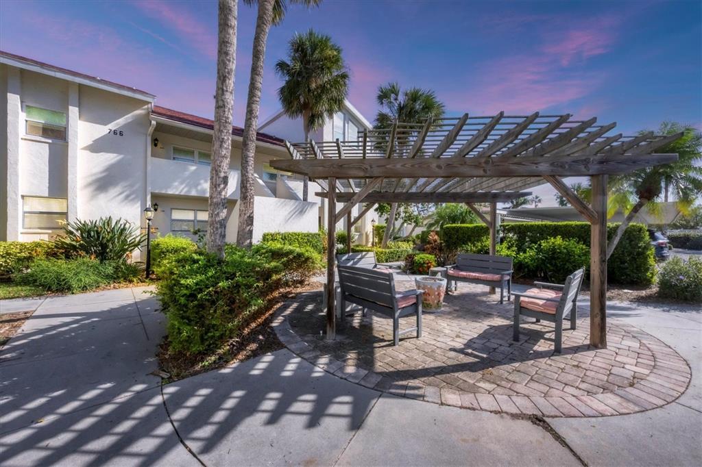 a view of a patio with table and chairs potted plants and palm trees