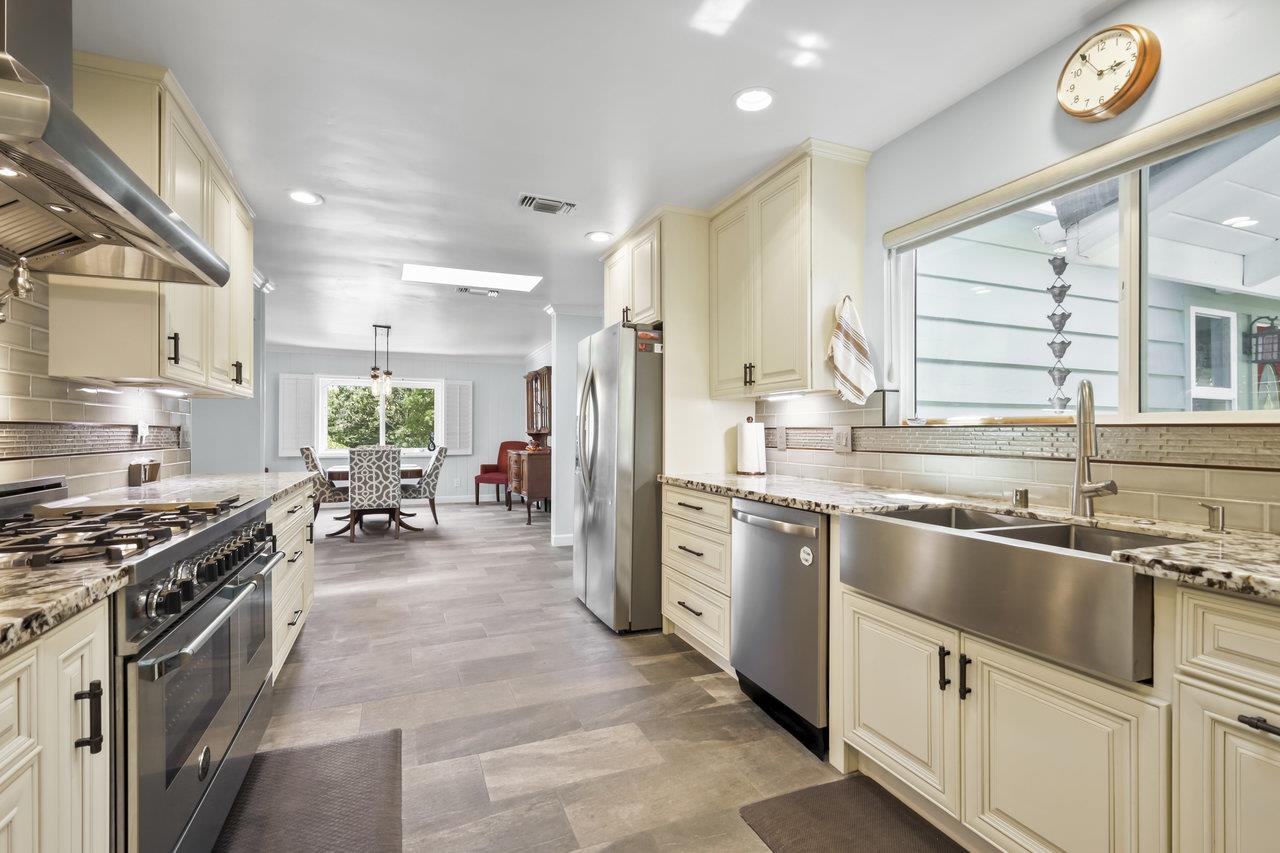 a kitchen with stainless steel appliances granite countertop a sink stove and refrigerator