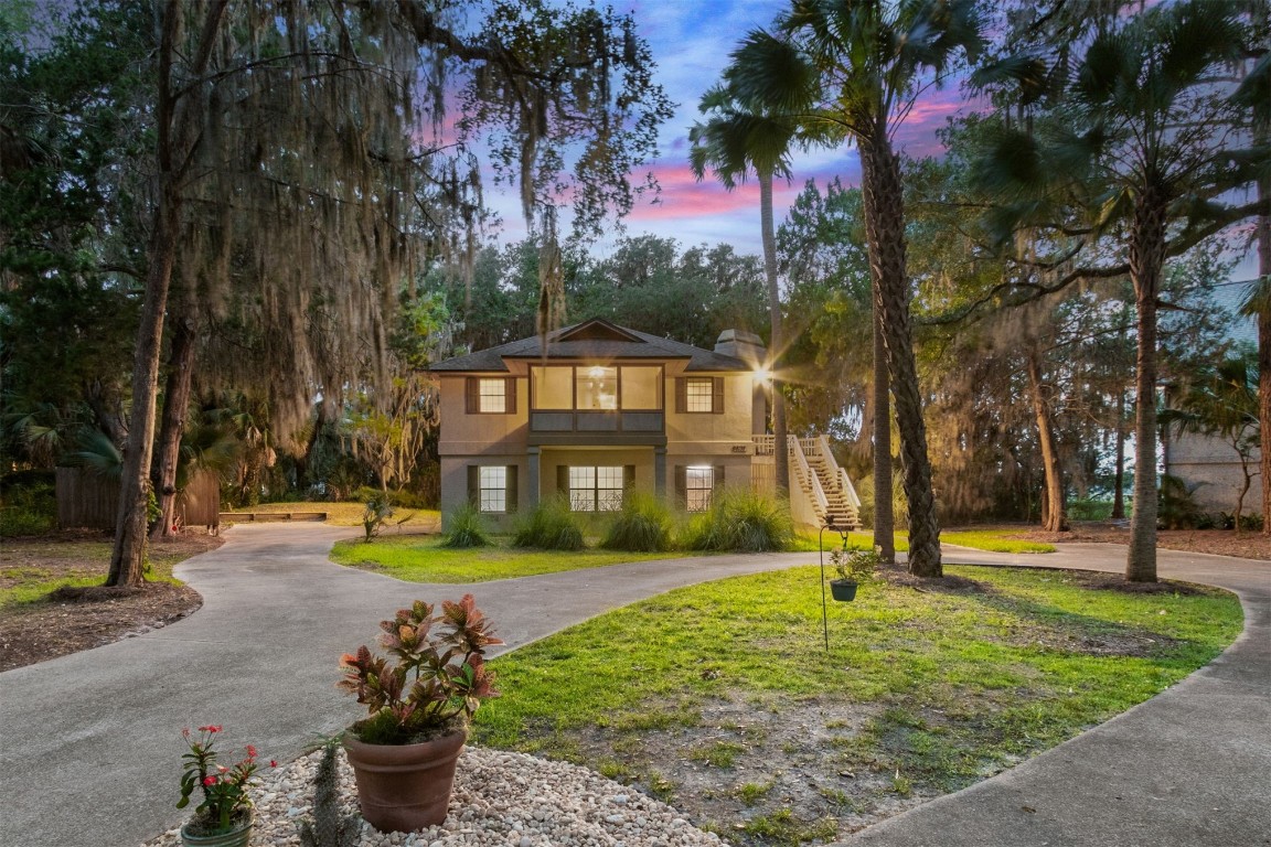 a front view of a house with garden and sitting area