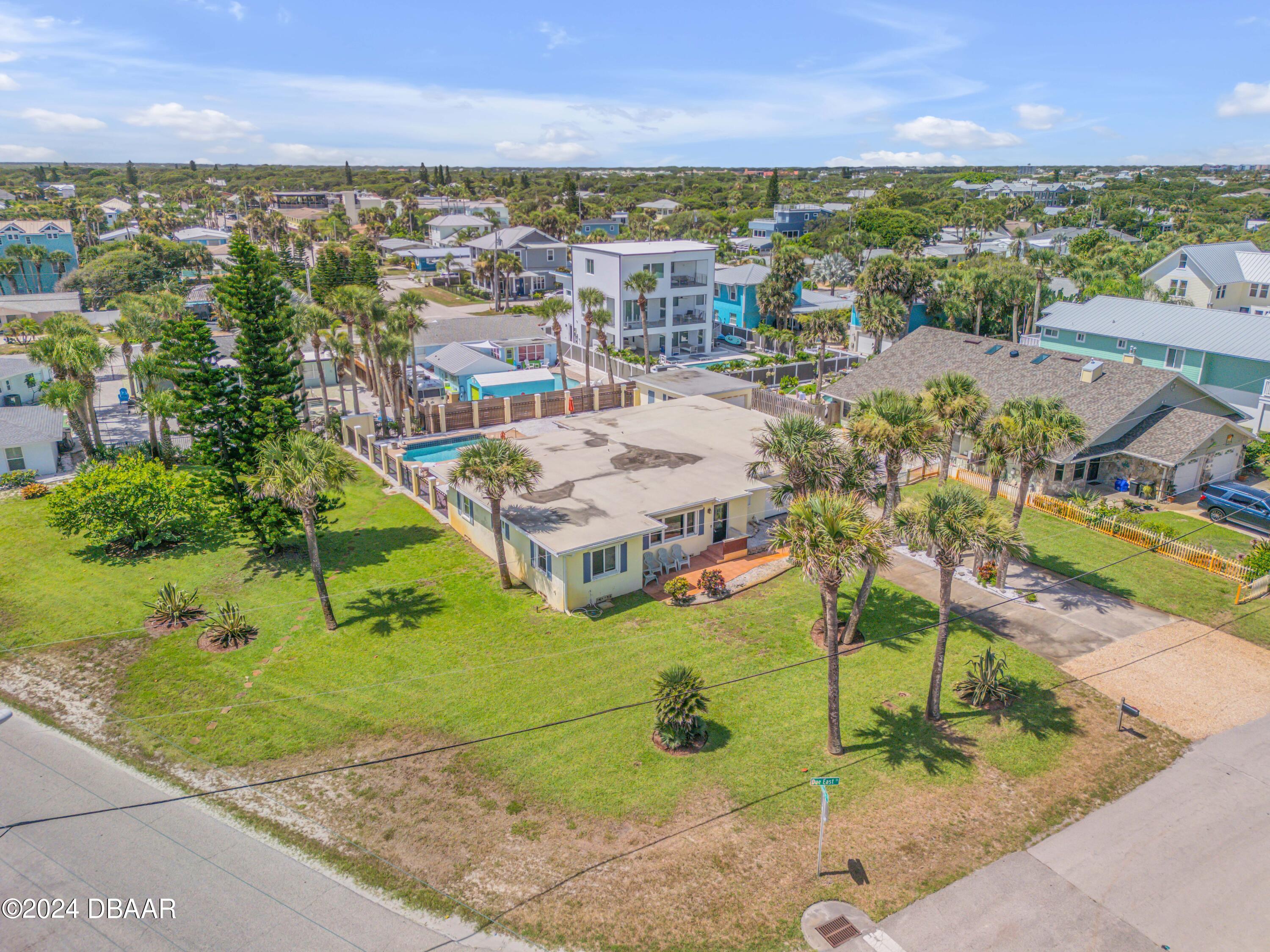 an aerial view of residential houses with outdoor space and trees